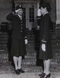 Lt Pickens receiving a salute from Ensign Wills. They are Black women in US Naval uniform, and are looking serious.
