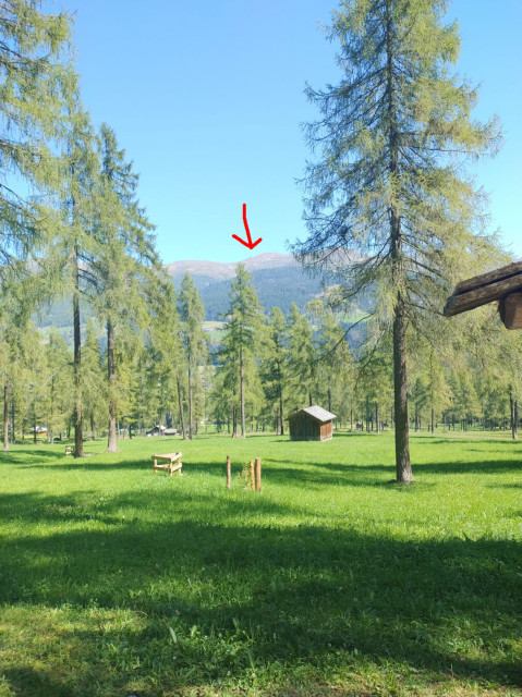 We entered the flat part of this day's hike. Th way into the valley leads through tree-covered grassland. I marked the Sillianer Hütte, where we started in the morning, with a red arrow.