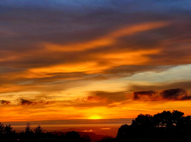 Streaks of orange across a cloudy sky at sunset.