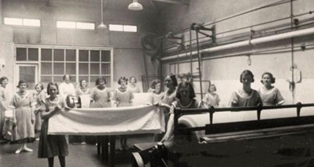 15 women and girls working in a laundry room.