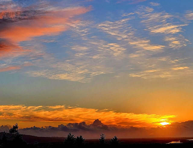 Lots of layers to the sunset sky. There was fog in the valley on the ground and  on the horizon. Low and high clouds turned orange and some blue sky.