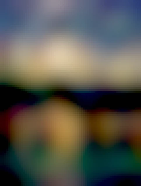 The yellow setting sun highlights the blue clouds with the reflection of the sky in a metal hand railing on a footbridge. The silhouette of trees can be seen in the background and the smooth water in the marsh on the lower right.