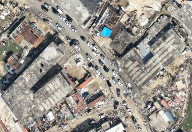 Hardware store with a tarp over part of the roof, grocery store with all solar panels ripped off the roof