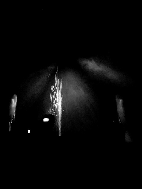 taken from behind bike handlebars.. there's a light on the bars and it's shining on water spray off the road which makes the spray look like a small firework like a sparkler in front of the bars