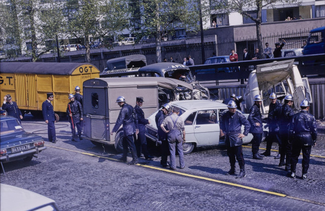 Un accident entre une fourgonnette et un autre véhicule dans une rue, avec plein de gendarmes encadrant la scène