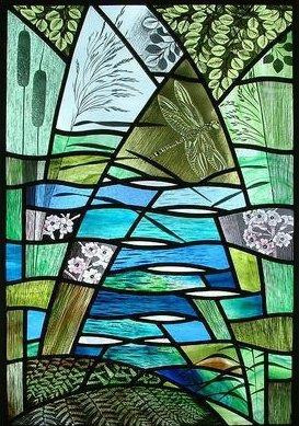 This image is a stained glass window depicting a natural landscape, featuring a dragonfly, reeds, and other foliage.