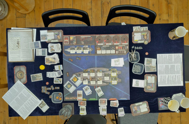 The board game of Battlestar Galactica being played on a tabletop. The game is over and the human faction has won. The human fleet's resource dials are all quite low and near defeat.