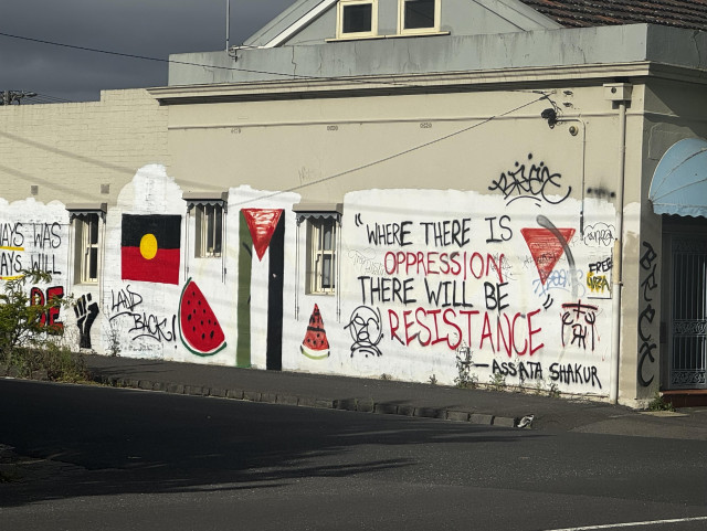 A wall mural reading “where there is oppression there will be resistance”, with symbols for Palestine, BLM, and indigenous people.