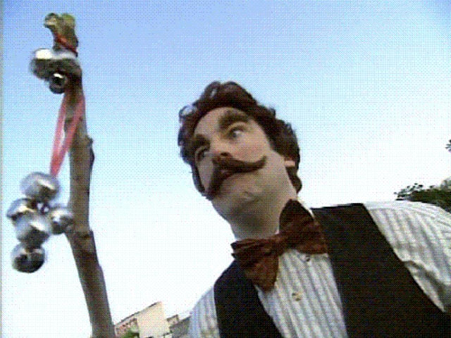 From Mr. Show with Bob & David, Bob Odenkirk is dressed in an "old timey"  look most especially his mustache that resembles Angus King's. He's also wearing a bow tie and vest and holding "the crime stick," a tree stick with bells tied to it. The skit lampoons a crime stopping tv personality from Chicago named J.J. Bittenbinder. Bob's character's name is F.F. "Woody" Cook. Every time I see Angus King I think he's a ridiculous character. 