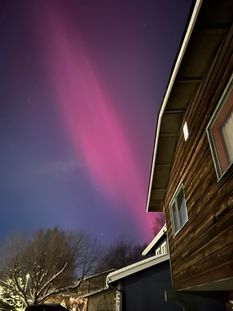 red aurora over head in clear dark sky