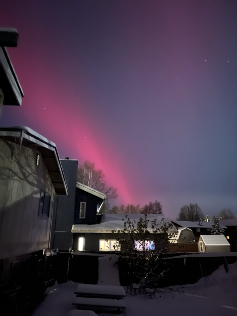 red aurora over head in clear dark sky