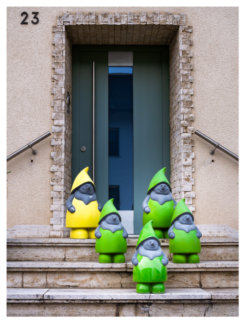 Einen Ansammlung großer Gartenzwerge auf Treppenstufen vor einer Haustüre stehend. Diese Gartenzwerge fallen durch ihren modernen Look aus dem Rahmen. Graue Haut, 4 mit grüner Kleidung und Mütze, einer gelb gewandet.