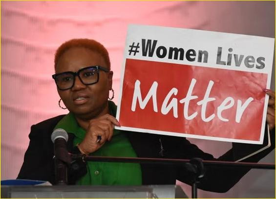 Lady holding up a sign which reads women lives matter