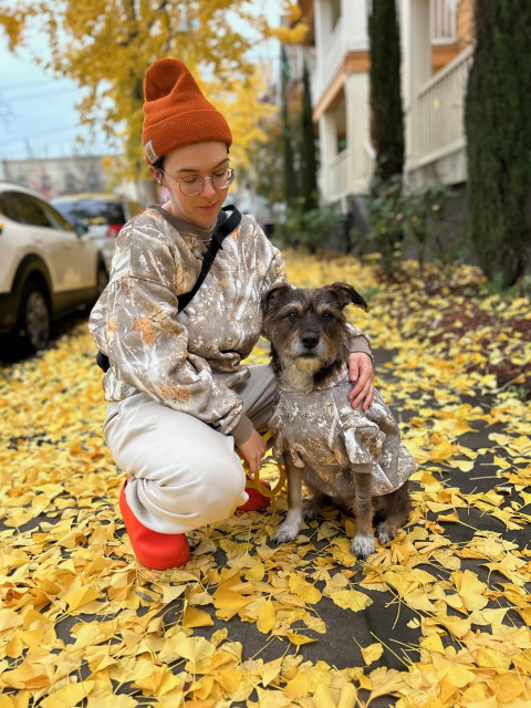My daughter kneels next to her Heinz 57 wiry dog on a sidewalk littered with extravagant yellow ginko tree leaves. Both are wearing matching sweaters. My daughter also has a jaunty knit cap perched atop her head and is wearing bright red kitchen clogs.
