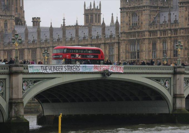 A huge white banner reading WE SUPPORT THE HUNGER STRIKERS WE SUPPORT PALESTINE ACTION