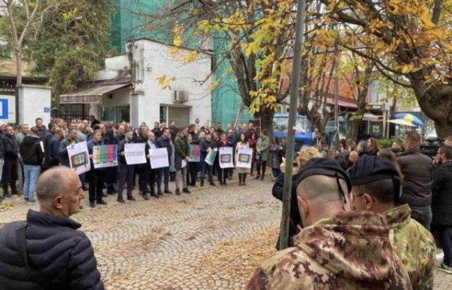 Protesters with placards outside their office building in Kosovo