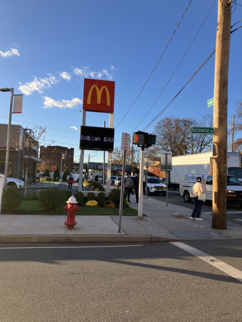 Photo of a McDonald's marquee with a digital sign showing the text "Debian GNU".