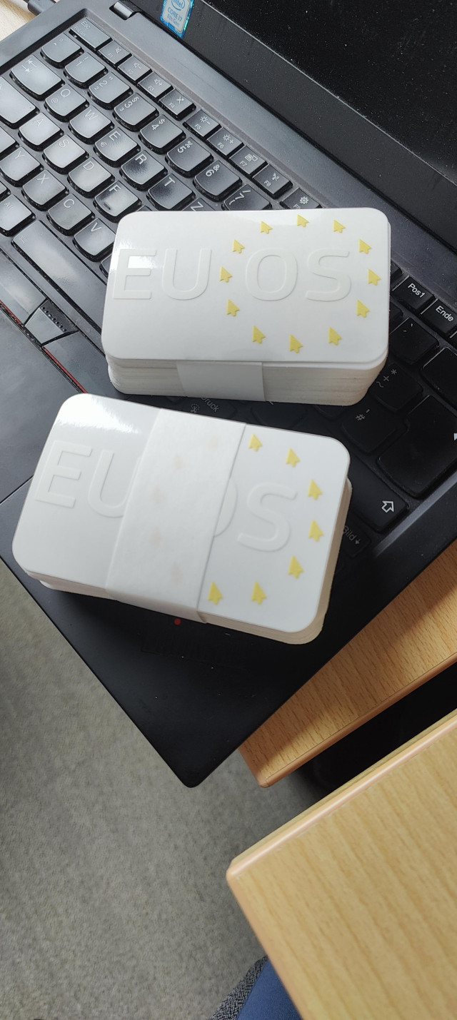 Picture of EU OS stickers laying on a Thinkpad keyboard