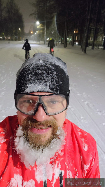 A snowy selfie on a bike path. Two or three other people pedalling in the background.