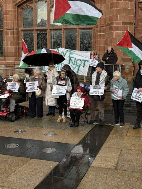 A group of protesters with flags and placards in Derry