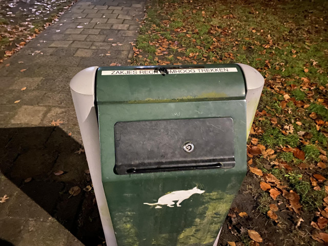 Dog poop box. It has a graphic of a pooping dog. Maybe a graphic of a dog poop bag would be more accurate 