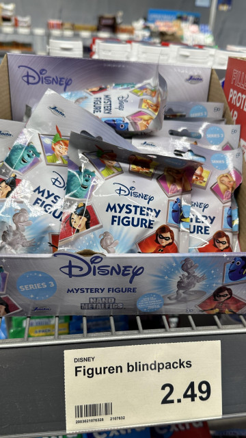 Box of Disney mystery figure blindpacks featuring various character images and "Nano Metalfigs" branding.