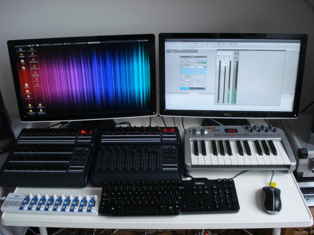 Photo of a computer setup with two screens, a mouse, a keyboard and some MIDI controller.