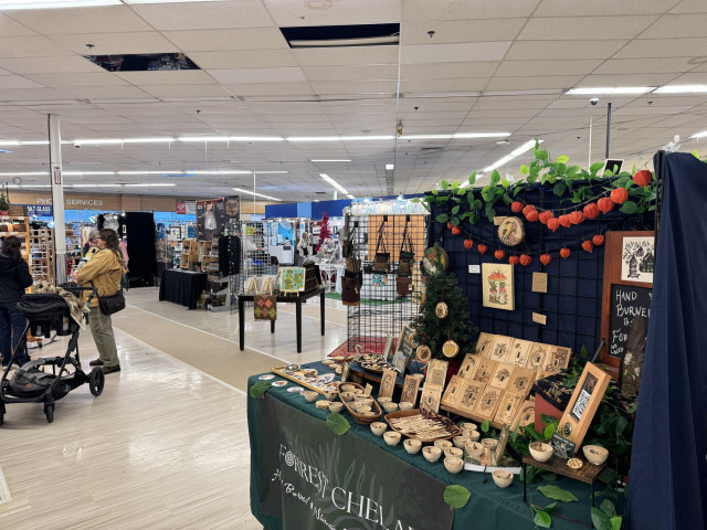 Craft booths at the Allied Arts Festival of the Arts. A booth with hand burned wooden gifts is in the foreground. 