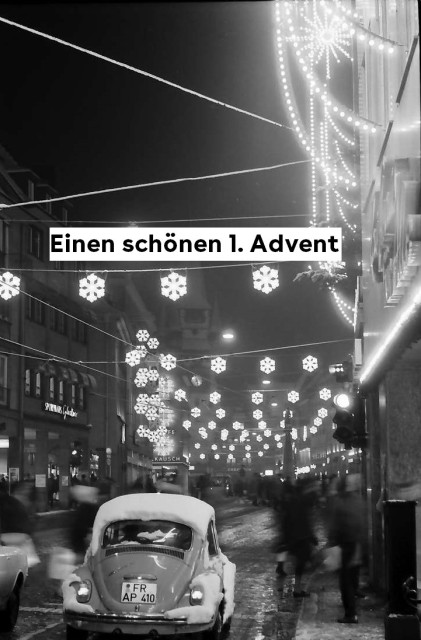 Schwarz-weiß Aufnahme: Freiburg 19. Dezember 1969. Kaiser-Joseph-Straße von der Franziskanerstraße aus aufgenommen. Im Vordergrund ein verschneiter VW-Käfer. Die Straße ist weihnachtlich geschmückt.