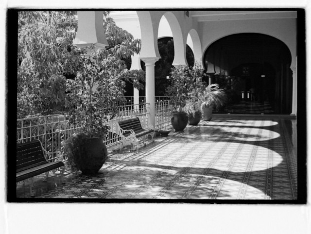Black and white photo of sunlit terrace with colonnade