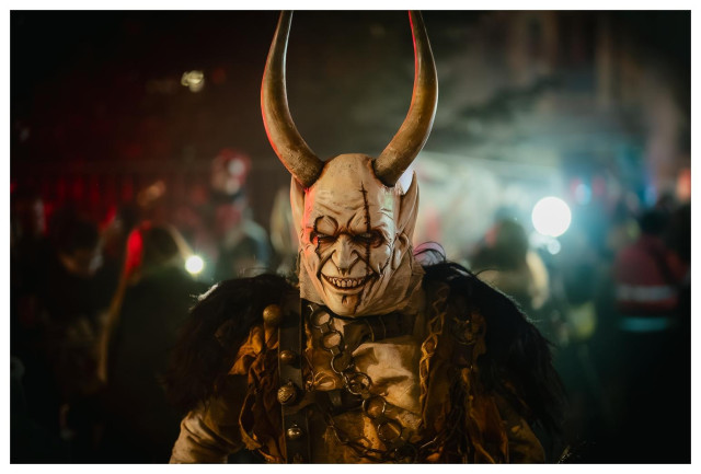 Gehörnte Teufelsartige Figur bei einem Nachtumzug.