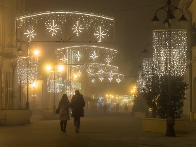 Fußgängerzone abends, Nebel. weihnachtlich beleuchtet, diffuses Licht.Zwei Menschen als Silhouette.