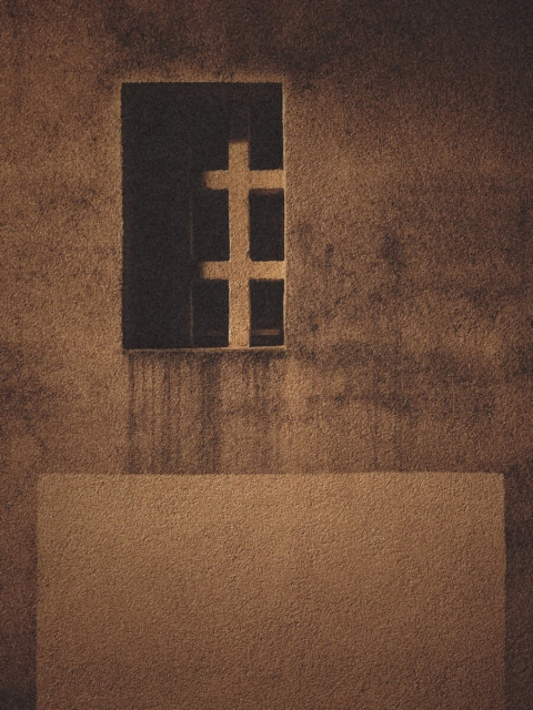 A concrete window illuminated by streetlights.