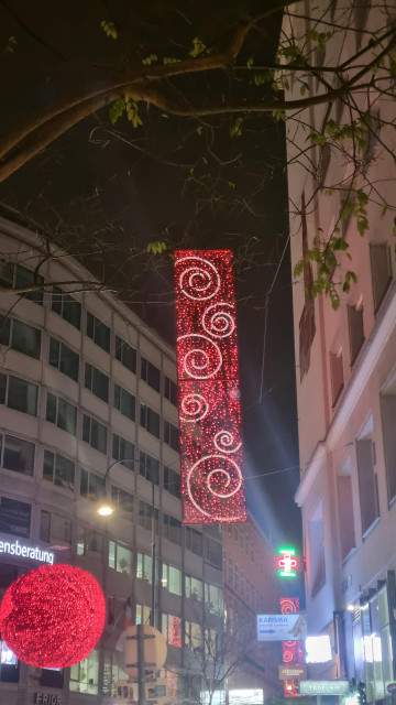 Christmas lights that are a big red banner with white swirls on it that remind of the Debian logo