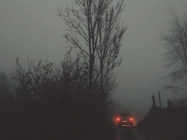 A lonely car lost in the misty dusk.