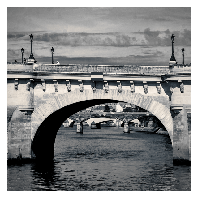 Daylight square photography.
A river guides the viewer's gaze through a series of bridge arches. Some clouds are poorly trying to organise in a similar manner