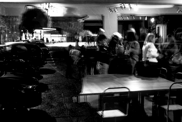 Night monochrome indoor photography.

Two night realities gently contend with each other through the huge window of a theatre hall, shadows and ghosts seeking a comfortable blur from which to enjoy the impromptu pince-fesses.