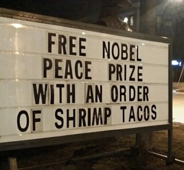 Restaurant marquee that reads "FREE NOBEL PEACE PRIZE WITH AN ORDER OF SHRIMP TACOS"