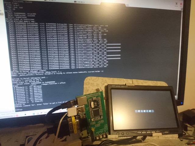 Allwinner V3s "device" maoe of a printed circuit board loosely attached to a small vga display and small keyboard, looking vaguely like a laptop. The PCB is not attached and just floating near the rest of the device, suspended by several cables. On the background is a larger display with a serial terminal showing the boot log ending in an early kernel panic.