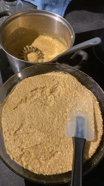 En kjele og en glassbolle med gul sennep i. Den største porsjonen er i glasssbollen, som også er nærmest kamera.