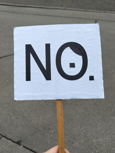 Schild mit "NO", wobei das O ein Hitlerbärtchen hat.