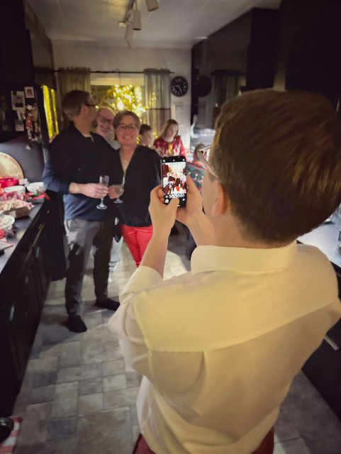 A photo of someone taking a photo of people at a party.