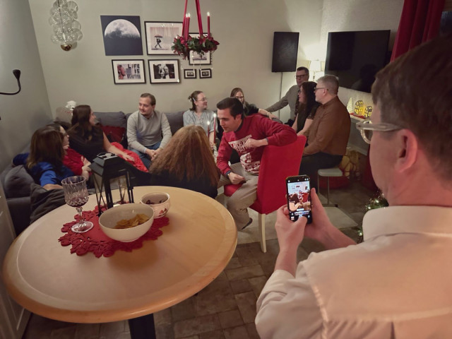 A photo of someone taking a photo of people at a party.