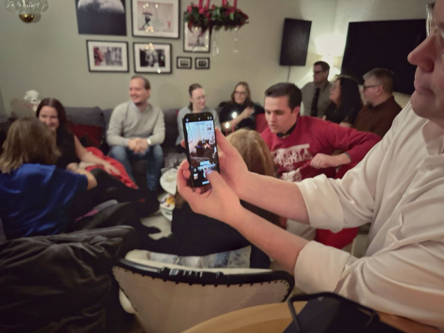 A photo of someone taking a photo of people at a party.
