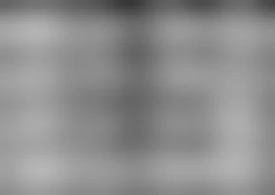 The image depicts four children playing a game known as "pik-a-pick" in what appears to be an urban street setting, likely from the late 19th or early 20th century. The black-and-white photograph shows two girls and two boys engaging in this traditional outdoor activity.

One girl is pulling on a long rope that connects one of her feet with another child's foot; she has pigtails tied at the end of each ponytail, which are typical attire for children during that era. Another girl follows closely behind her, also wearing similar clothing and sporting pigtails. The boys have their own versions of this game: they hold sticks in a manner reminiscent of playing tug-of-war.

They all wear coats with hoods and trousers suitable for cold weather, indicating the season might be fall or winter. Their faces display focused expressions as if concentrating on winning the game.

The background features an urban environment with brick buildings partially visible through some form of barrier that separates them from a more open space. This suggests they are in a city's Chinatown area during this time period based on historical context and visual cues such as architecture style, attire, and overall atmosphere captured within Genthe's photograph series.

Overall, it portrays an innocent moment of children enjoying their playtime amidst the bustling urban backdrop typical for that era.