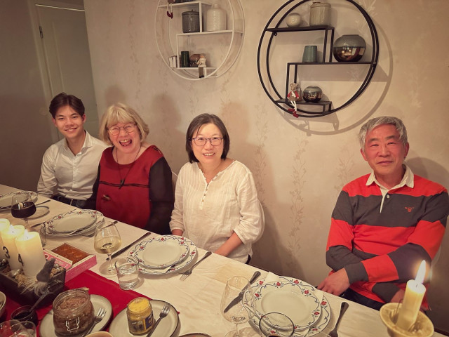 The other 4 people seated at a table with the Xmas food on it.