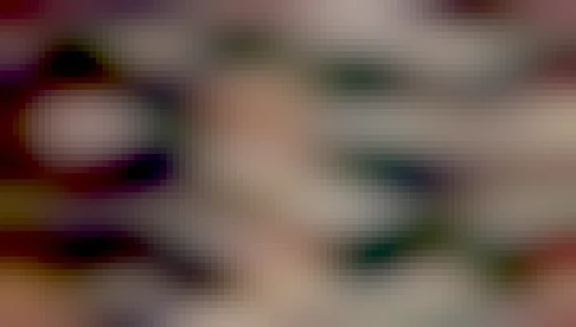 Photo of Wendy Carlos surrounded by keyboards, electronic music equipment, and holding a Sphynx cat in her lap. Wendy is a white woman with shoulder length brown hair with an endearing and awkward smile.