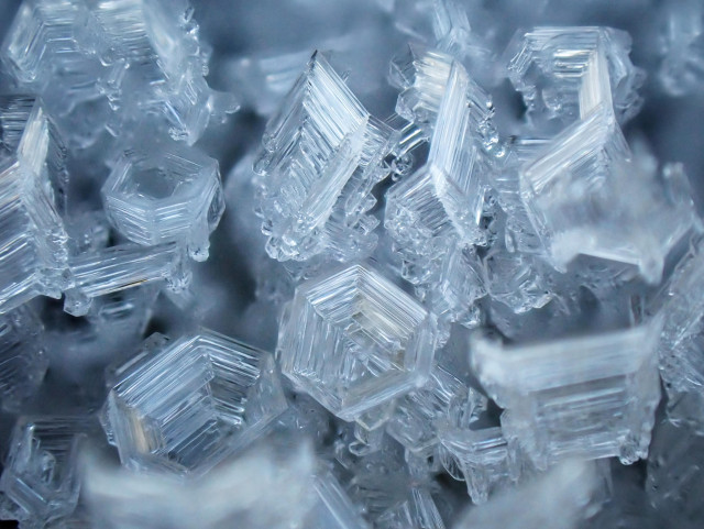Close-up image showing the delicate, fascinating structure of hoar frost crystals formed on an iron gate
