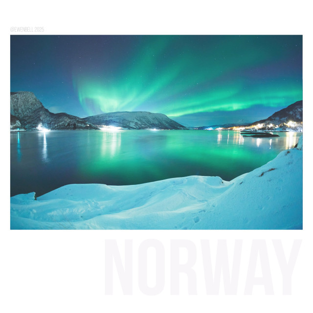 Classic radial pattern of an aurora event, bursting out of the western sky. These bands run overhead and connect with the eastern horizon. Reflections on the fjord are an added bonus, and the 11mm also picks up the snow covered shoreline.