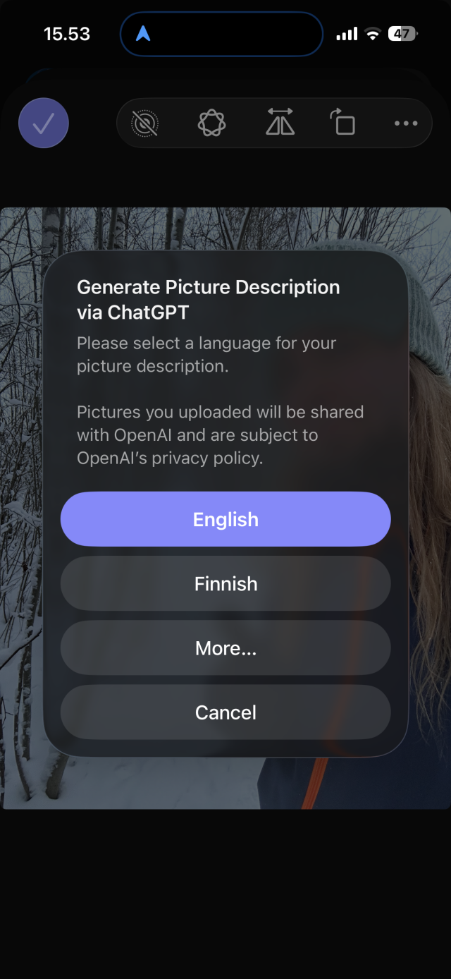 A screenshot, text: 15.53
Generate Picture Description via ChatGPT
Please select a language for your picture description.
Pictures you uploaded will be shared with OpenAl and are subject to OpenAl's privacy policy.
English
Finnish
More...
Cancel

In the background: A person dressed warmly in winter clothing outdoors in a snowy forest.